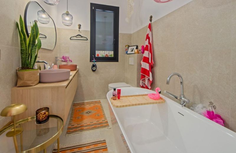 Ensuite bathroom with freestanding bath and dusty pink basin in Palma Mallorca.