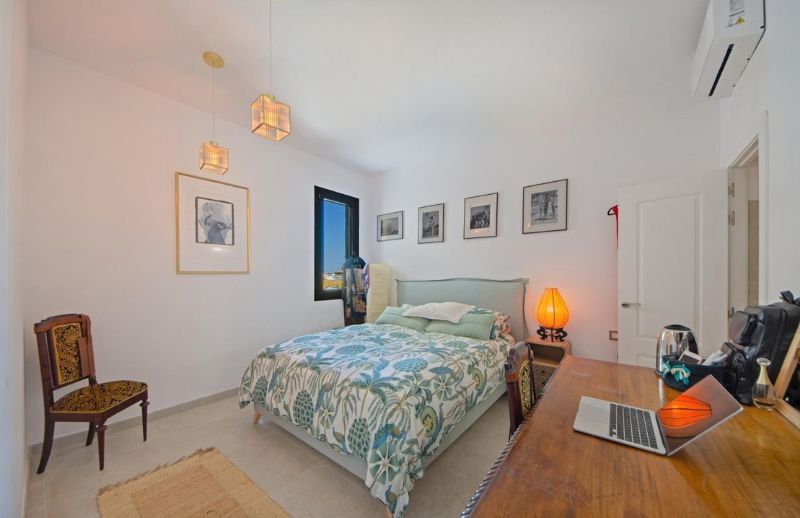 Renovated guest bedroom with vintage wooden desk and neutral tones in Palma