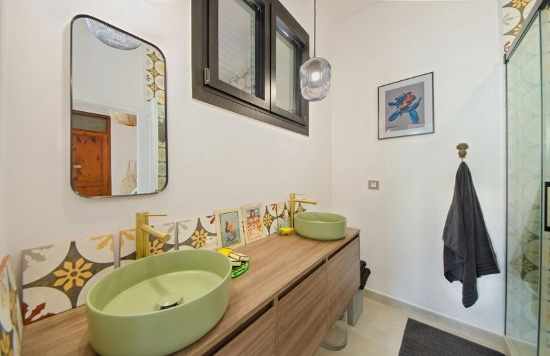 Bathroom with dual green basins in Palma renovated by BuildWell Mallorca
