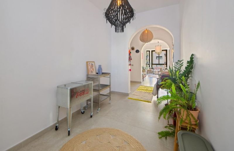 Spacious entrance hallway with archways, plants, and jute rug in Palma Mallorca